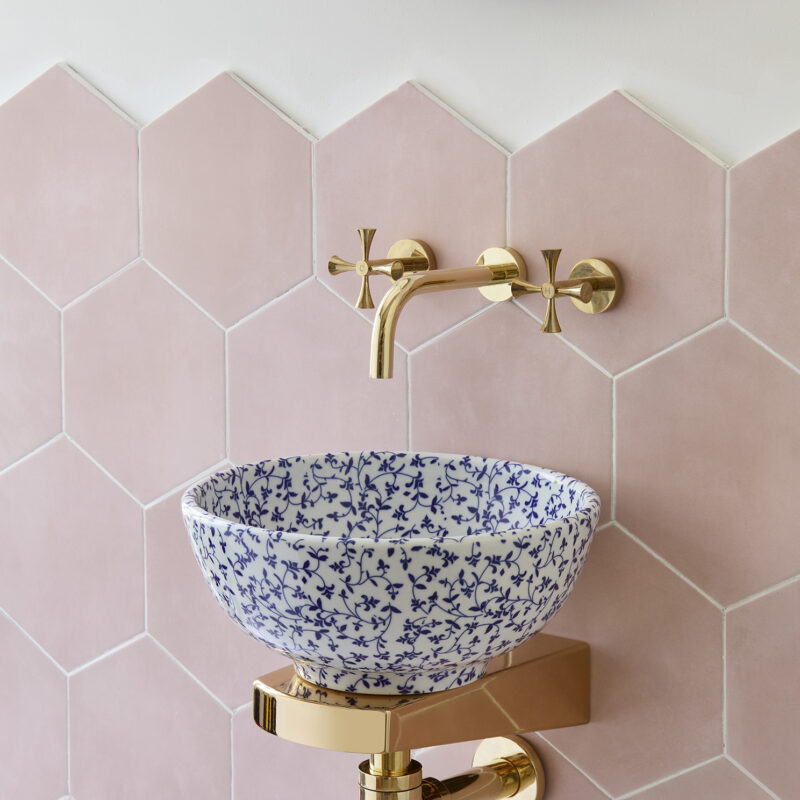 Mini Madeline basin against pink tiled bathroom wall, with Mini Theo Tap, Mini Theo Waste & Bottle Trap, and Mini Finn support bracket.