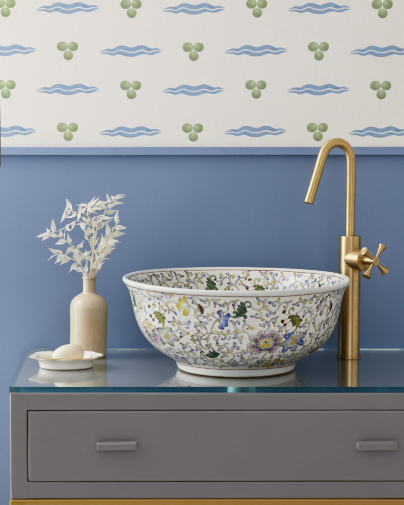 Bathroom with London Basin Company Florentine luxury bathroom sink on glass top vanity unit with white patterned wallpaper behind