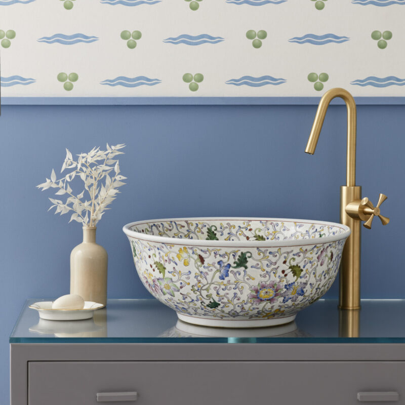 Bathroom with London Basin Company Florentine luxury bathroom sink on glass top vanity unit with white patterned wallpaper behind